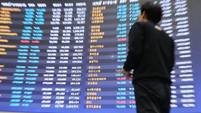 서울 여의도 한국거래소 홍보관에서 한 시민이 전광판 앞을 지나는 모습. 연합뉴스