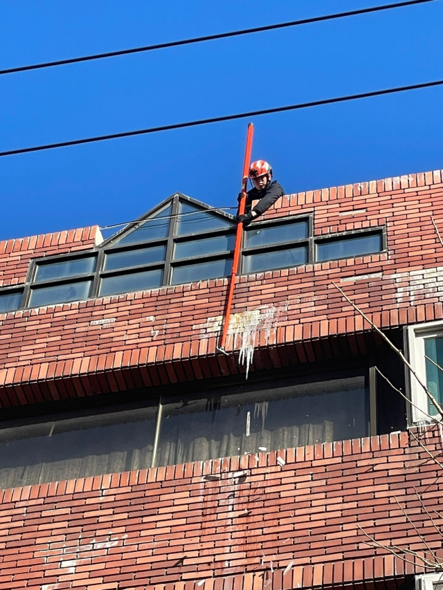 소방관이 23일 중구 중앙동에서 고드름을 제거하는 모습. 부산소방재난본부 제공