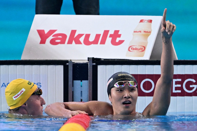 김우민(오른쪽)이 12일(한국시간) 카타르 도하 어스파이어돔에서 열린 2024 도하 국제수영연맹 세계선수권대회 남자 자유형 400m 결승에서 우승을 확인하고 기뻐하고 있다. AFP연합뉴스