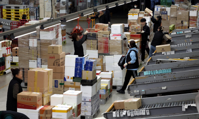 설 명절을 앞둔 지난달 30일 부산 강서구 부산우편집중국에서 직원들이 소포와 택배 물량을 분류하기 위해 분주하게 움직이고 있다. 정종회 기자 jjh@