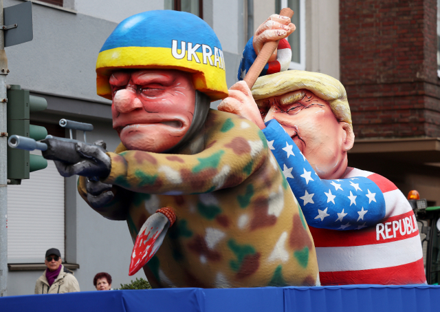12일(현지시간) 독일 뒤셀도르프에서 ‘장미의 월요일’ 카니발 행사용으로 장식된 도널드 트럼프 전 미국 대통령을 본뜬 인형이 우크라이나 병사 인형을 뒤에서 찌르고 있다. EPA연합뉴스