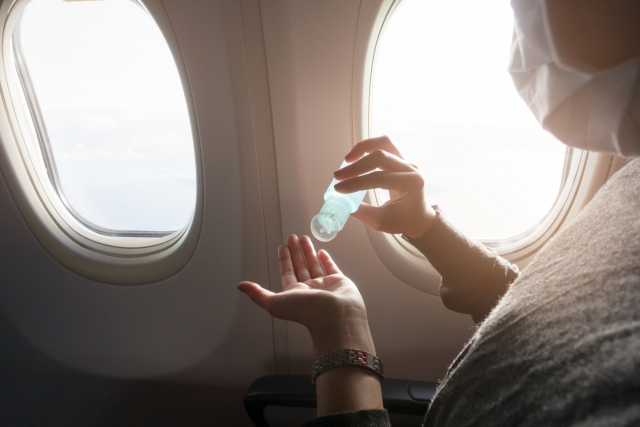 한 항공기 승객이 기내에서 소형 손 세정제를 사용하고 있다. 이미지투데이