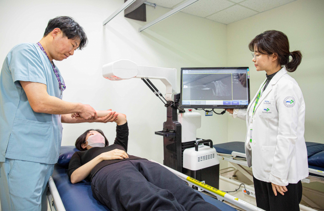 부산대병원 윤진아 재활의학과 교수(오른쪽)와 최수홍 물리치료사가 림프부종 치료실에서 림프부종 환자를 치료하고 있다. 부산대병원 제공
