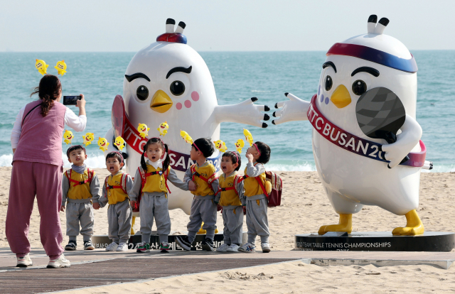 BNK부산은행 2024 부산세계탁구선수권대회 개막을 하루 앞둔 15일 오후 부산 해운대해수욕장을 찾은 아이들이 백사장에 설치된 탁구선수권대회 마스코트 앞에서 사진을 찍고 있다. 정종회 기자 jjh@