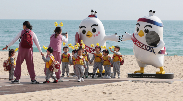 ‘BNK부산은행 2024 부산세계탁구선수권대회’ 개막을 하루 앞둔 15일 오후 부산 해운대해수욕장을 찾은 아이들이 백사장에 설치된 대회 마스코트 앞에서 사진을 찍고 있다. 정종회 기자 jjh@