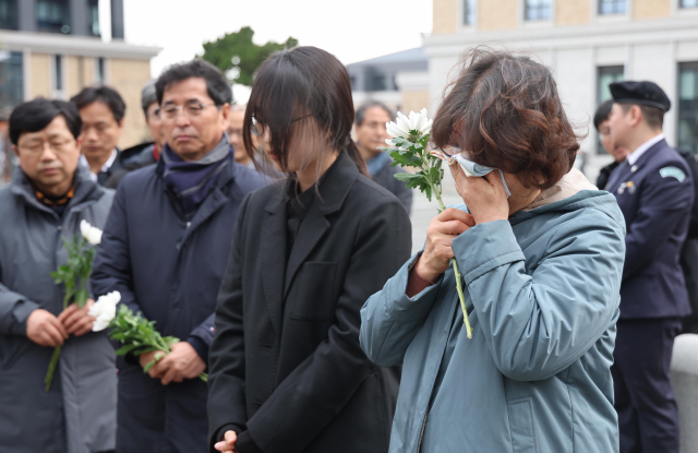 15일 오후 부산 금정구 부산외국어대학교 내 추모공원에서 경주 마우나오션리조트 참사 10주기 추모식이 열렸다. 추모식을 마친 후 한 유가족이 헌화를 하며 눈물을 흘리고 있다. 이재찬 기자 chan@