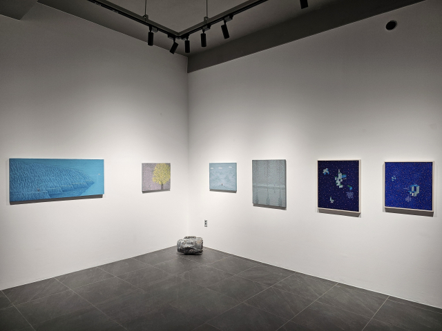 M543 갤러리 벽에 이인철 작가의 작품들(왼쪽 처음부터 네 번째까지)과 성현섭 작가의 작품(왼쪽 다섯 번째, 여섯 번째)이 걸려있고, 그 아래로 정희욱 작가의 작품이 놓여있다. M543 갤러리 제공