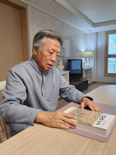 최화웅 씨가 자택에서 <울말섬 찬가>에 대한 이야기를 하고 있다.