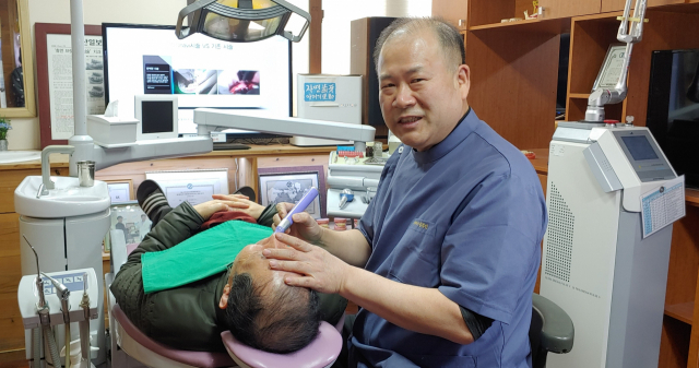 덴타피아치과의원 김경진 원장이 임플란트 시술 환자를 진료하고 있다. 덴타피아치과의원 제공