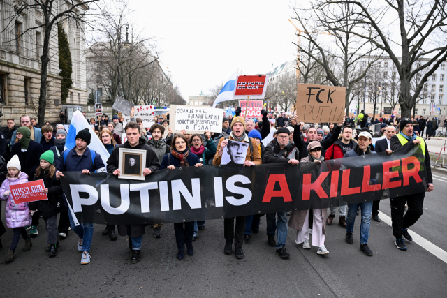 18일 독일 베를린의 러시아 대사관 인근 거리에서 알렉세이 나발니의 의문사에 항의하는 시위대가 ‘푸틴은 살인자’라는 문구가 적힌 현수막을 들고 행진하고 있다. 로이터연합뉴스