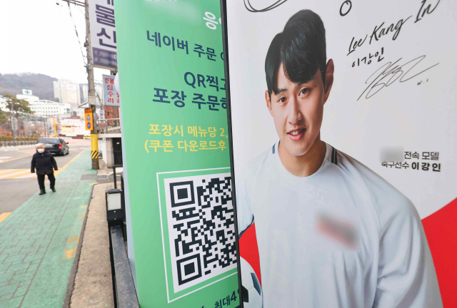 이강인이 주장 손흥민과 갈등을 빚은 사실이 알려지면서 이강인을 광고모델로 발탁한 기업들이 곤혹을 겪고 있다. 서울 한 음식점 앞에 설치된 이강인 광고물. 연합뉴스