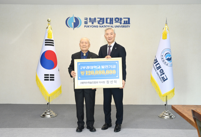 장선덕(왼쪽) 전 국립부경대 총장이 장영수 현 총장에게 발전기금을 전달하고 기념촬영하고 있다.