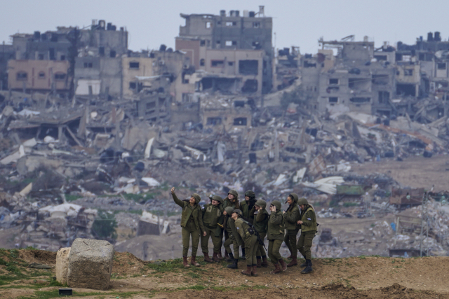 이스라엘 여군들이 19일 이스라엘군 공격으로 폐허가 된 가자지구를 배경으로 사진을 찍고 있다. 이날 하마스 측 가자지구 보건부는 지난해 10월 7일 이스라엘·하마스 전쟁 발발 이후 가자지구 사망자가 2만 9092명으로 집계됐다고 밝혔다. AP연합뉴스