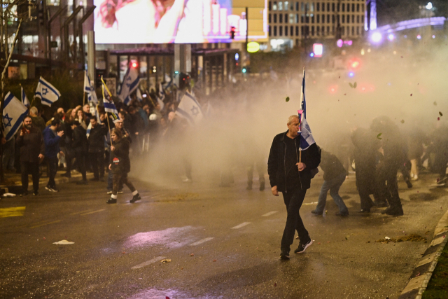 이스라엘 전시내각에 반대하는 시위대가 24일 이스라엘 경찰의 물대포 진압에도 집회를 하고 있다. 로이터연합뉴스