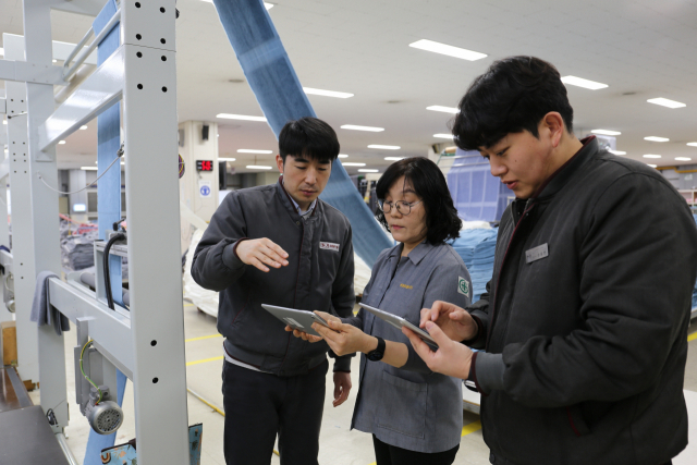 송월타올 직원들이 29일 동서대 방송영상학과에서 제작한 영상 매뉴얼을 이용해 작업을 수행하고 있다. 송월타올 제공