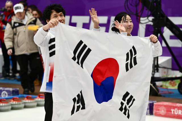 청각장애 컬링 믹스 더블 국가대표 윤순영(왼쪽)과 김지수가 5일(현지시간) 튀르키예 에르주룸 컬링홀에서 열린 2023 에르주룸 동계데플림픽 컬링 믹스 더블(혼성 2인조)에서 은메달을 획득한 뒤 태극기를 들고 환하게 웃고 있다. 연합뉴스