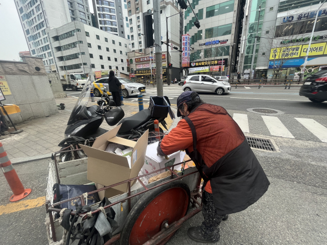 6일 부산 동래구의 한 도로에서 이 모(64) 씨가 폐지를 정리하고 있다. 양보원 기자 bogiza@