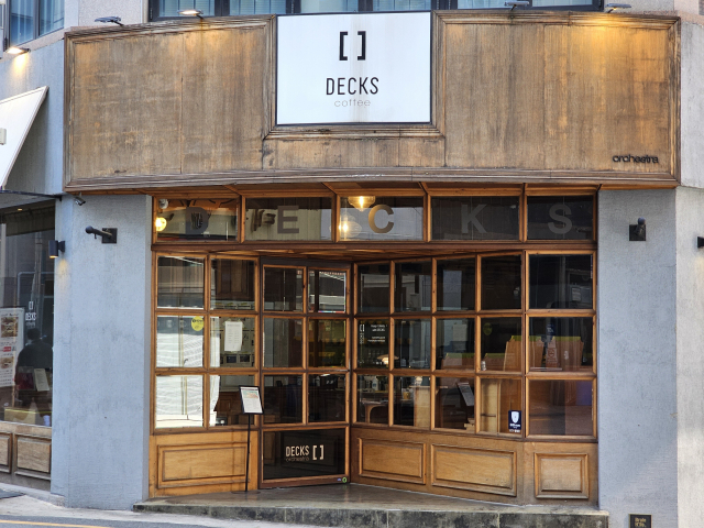 덱스 커피 정문인데, 처음엔 어디로 들어가야 할지 혼란스러울 수 있어. 하단에 짙은 밤색으로 덱스커피 로고가 그려져 있는 부분이 출입문이니까 밀고 들어가면 돼. 나도 헷갈리더라고. 조경건 부산닷컴 기자