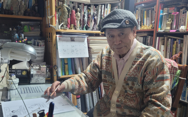 안기태 화백이 부산 해운대구 자택 작업실에서 시사만화가로 걸어온 길을 이야기하고 있다.
