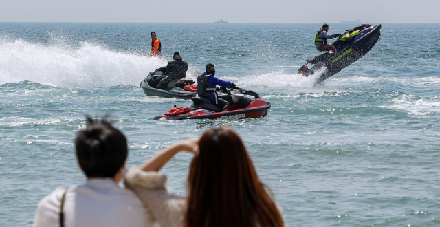 전국적으로 초여름 같은 날씨가 이어진 14일 부산 해운대구 해운대해수욕장 앞 바다에서 수상오토바이 무리가 질주하고 있다. 김종진 기자 kjj1761@