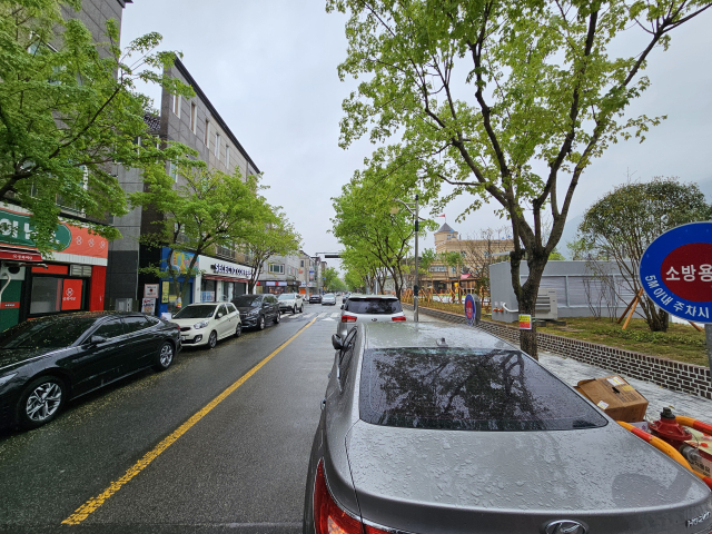 이달 말 준공을 앞두고 마무리 공사 중인 황산마을 공영주차장 조성사업 인근 도로에 주차된 차량 전경. 김태권 기자