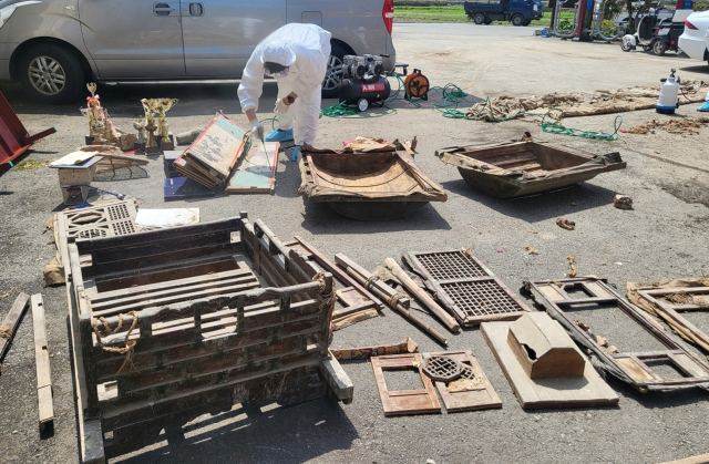 고성군 영현면 영부리 마을회관 신축공사 준비 과정에 옛 마을창고 천장 시렁에서 1950년대 사용된 것으로 추정되는 혼례용품이 무더기로 발견됐다. 고성박물관 학예사가 이관에 앞서 현장에서 발견된 민속품 세척작업을 하고 있다. 고성군 제공