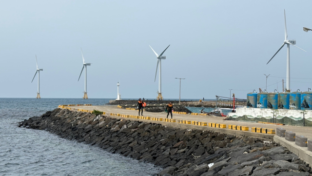 제21대 국회의 임기가 약 40일 남은 가운데 수산업계가 22일 ‘해상풍력 특별법 제정’을 촉구하는 성명서를 발표하고, 적극적인 입법 건의를 추진키로 결의했다. 지난달 29일 제주 한경면 탐라해상풍력발전단지 앞에서 물질을 마친 해녀들이 돌아오고 있는 모습. 연합뉴스