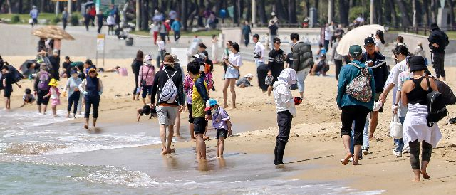 전국적으로 초여름 같은 날씨가 이어진 14일 부산 해운대구 해운대해수욕장을 찾은 시민과 관광객들이 맨발걷기를 즐기고 있다. 김종진 기자 kjj1761@