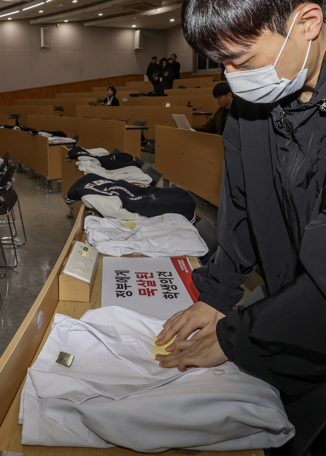 지난달 19일 부산대 양산캠퍼스 의과대학에서 열린 의과대학 교수협의회의 기자회견에서 한 의대생이 책상에 가운을 올려놓고 있다. 김종진 기자 kjj1761@