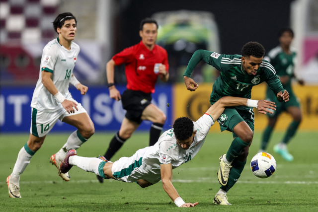 FBL-ASIA-AFC-U23-IRQ-KSA 사진설명 Iraq's defender #04 Zaid Tahseen falls during a challenge for the ball against Saudi Arabia's midfielder #17 Haitham Asiri during the AFC U23 Asian Cup Qatar 2024 Group C match between Saudi Arabia Iraq at Khalifa International Stadium in Doha on April 22, 2024. (Photo by KARIM JAAFAR / AFP)