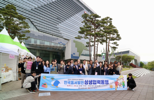지난 24일 한국동서발전 본사 정문 앞 광장에서 열린 '상생협력 직거래장터'에 참석한 울산지역 소상공인과 동서발전, 중구청, 혁신도시 공공기관 등 행사 관계자들이 기념사진을 촬영하는 모습. 동서발전 제공