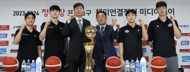 부산 KCC와 수원 KT 감독·선수들이 25일 서울 KBL센터에서 열린 프로농구 챔피언결정전 미디어데이에서 우승트로피를 배경으로 파이팅을 외치고 있다. 연합뉴스