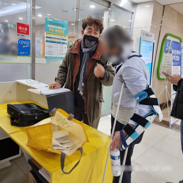 비접촉 사고로 다쳤다고 주장한 B 씨가 목발과 보호대를 착용한 채 경찰에 검거되고 있다. 경찰은 B 씨가 상시적으로 목발과 보호대를 착용하고 생활한 것으로 보고 있다. 부산경찰청 제공