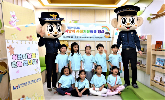 ‘어린이날 미아 방지를 위한 아이 지문등록’ 행사에서 경찰관과 아이들이 함께 사진을 찍고 있다. KTL 제공