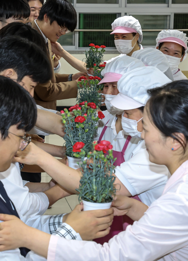 어버이날을 하루 앞둔 7일 오후 부산 동래구 용인고등학교에서 학생들이 학교 급식실 직원분들에게 감사의 카네이션을 전달하고 있다. 김종진 기자 kjj1761@