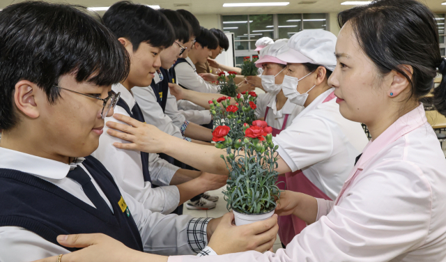 어버이날을 하루 앞둔 7일 오후 부산 동래구 용인고등학교에서 학생들이 학교 급식실 직원분들에게 감사의 카네이션을 전달하고 있다. 김종진 기자 kjj1761@