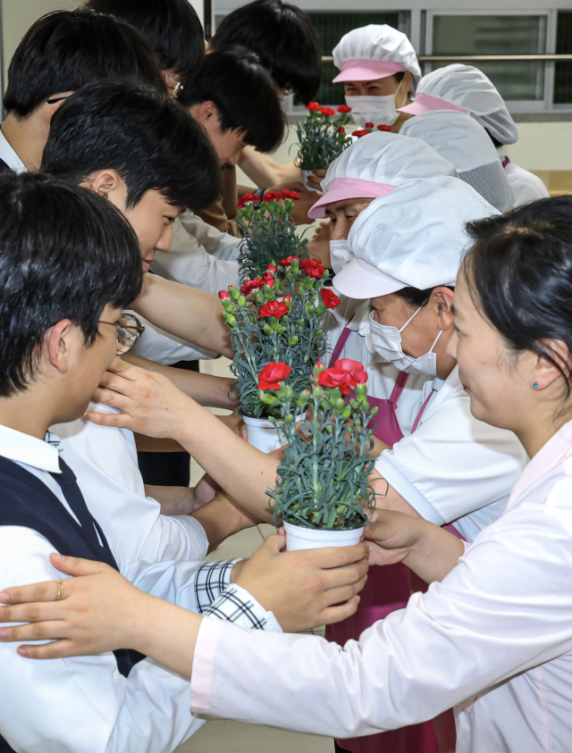 어버이날을 하루 앞둔 7일 오후 부산 동래구 용인고등학교에서 학생들이 학교 급식실 직원분들에게 감사의 카네이션을 전달하고 있다. 김종진 기자 kjj1761@