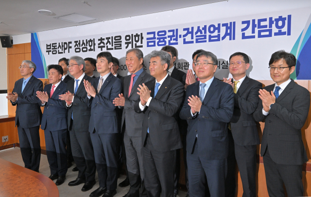 부동산 프로젝트파이낸싱(PF) 정상화를 위해 신디케이트론(공동대출)을 구성하기로 한 은행·보험권이 시장 수요가 있을 때마다 자금을 대는 방식을 택할 것으로 보인다. 이복현 금융감독원장이 지난달 21일 서울 영등포구 주택건설회관에서 열린 ‘부동산PF 정상화 추진을 위한 금융권·건설업계 간담회’에서 참석자들과 기념 촬영을 하고 있다. 연합뉴스