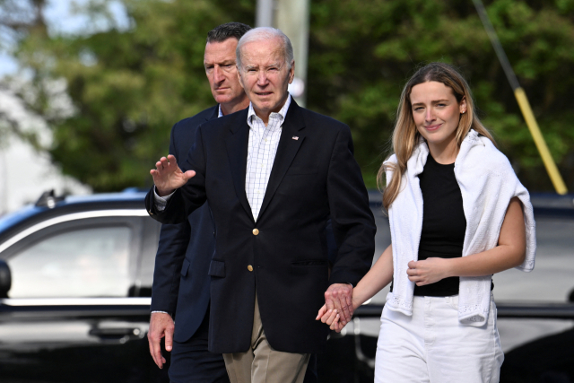 조 바이든 미국 대통령이 12일(현지시간) 손녀 피니건 바이든의 손을 잡고 델라웨어주 레호보스 비치의 세인트 에드먼드 교회를 떠나고 있다. 바이든 대통령은 레호보스 비치에서 가족과 주말을 보냈다. 연합뉴스