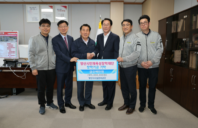 양산시시설관리공단이 양산종합운동장 관람석 복원과정에서 절감한 예산 덕분에 받은 포상금 500만 원을 지역인재육성장학재단에 기탁한 뒤 기념사진을 찍고 있다. 양산시 제공