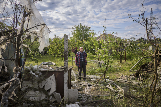 18일(현지시간) 러시아의 우크라이나 주택가 폭격으로 일부 건물이 무너진 가운데 주민이 이를 살펴보고 있다. EPA연합뉴스