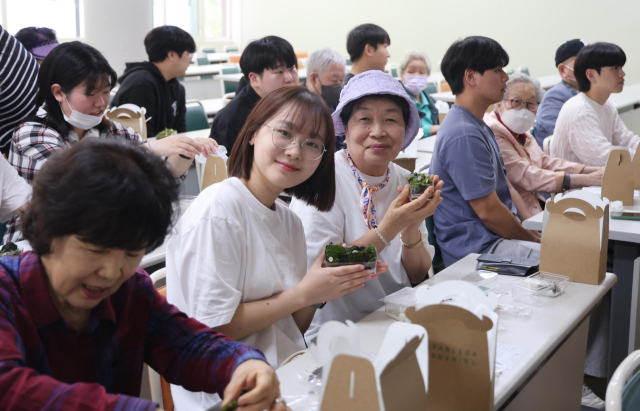 지난달 22일 오후 부산 금정구 부산가톨릭대 신학교정 이정식요한관 강의실에서 어르신들과 재학생들이 함께 테라리움 제작 원예활동을 하고 있다. 이재찬 기자 chan@