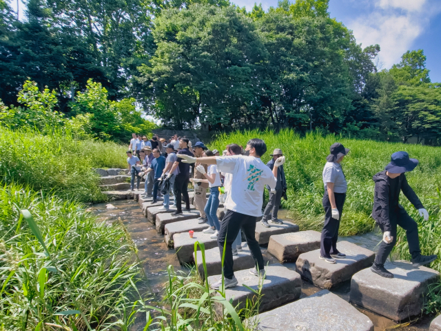 선박해양플랜트연구소(KRISO) 직원들이 탄동천으로 EM흙공을 던지고 있다. KRISO 제공