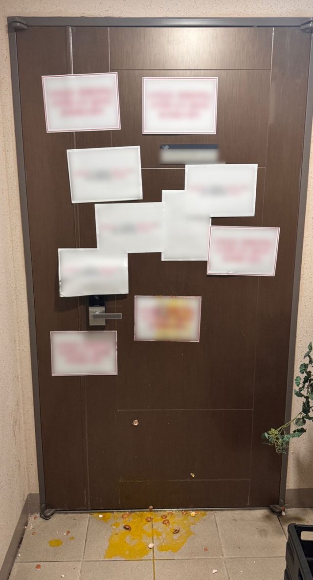 현충일인 지난 6일 욱일기를 내걸었던 부산의 한 아파트 주민집 현관에 해당 주민의 행동을 비난하는 글이 부착돼 있다. 연합뉴스