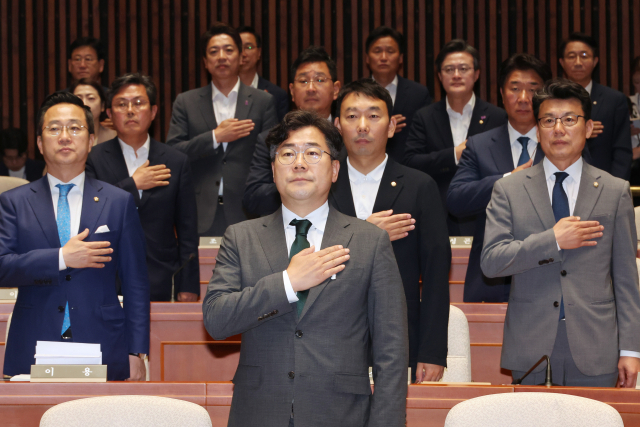 더불어민주당 박찬대 원내대표와 진성준 정책위의장 등 의원들이 13일 오전 서울 여의도 국회에서 열린 정책 의원총회에서 국기에 경례하고 있다. 연합뉴스