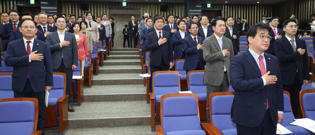 국민의힘 의원들이 13일 오전 국회에서 열린 의회정치 원상복구 의원총회에서 국기에 경례하고 있다. 연합뉴스