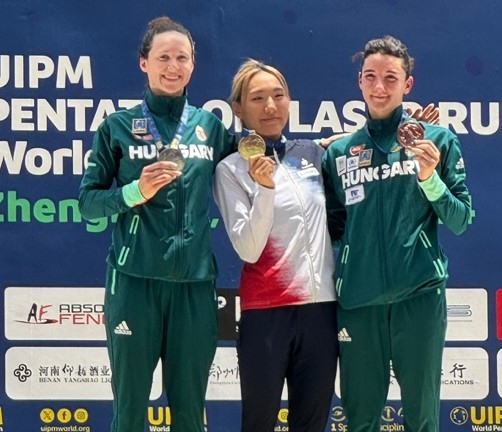 성승민(가운데·한국체대)이 15일 중국 정저우에서 열린 국제근대5종연맹(UIPM) 2024 세계선수권대회 여자 개인전 결승에서 펜싱, 수영, 승마, 레이저 런(사격＋육상) 합계 1434점을 획득해 우승을 차지한 뒤 단상에 올라 금메달을 목에 걸고 있다. 대한근대5종연맹 제공