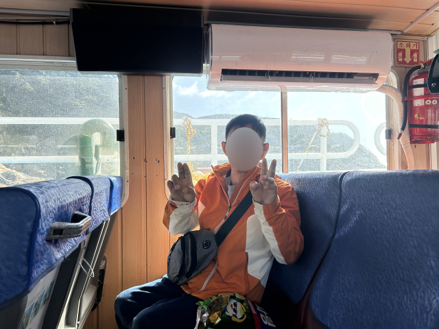 지난해 12월 1일 세상을 떠난 무연고 사망자 고 박동현(가명) 씨가 생전 유람선에 탑승해 즐거워하는 모습. 활동지원사 정영이 씨는 평소 창밖너머 다대포 앞바다를 지나다니는 화물선을 보고 감탄하는 그를 위해 함께 유람선을 타러 가기도 했다. 사하두바퀴장애인자립생활센터 제공