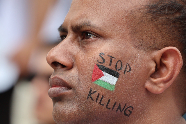 지난달 23일 서울에서 열린 '팔레스타인인들과 연대하는 사람들' 주최 6·23 전국 집중 행동의 날 집회에서 페이스페인팅을 한 참가자가 발언을 듣고 있다. 연합뉴스