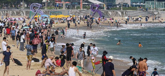 부산 지역 공설해수욕장 개장 첫날인 1일 오후 해운대해수욕장에 피서객들이 여유로운 시간을 즐기고 있다. 김종진 기자 kjj1761@